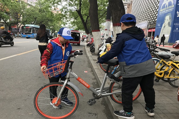 图为：新华小记者摆放乱停乱放的共享单车.jpg