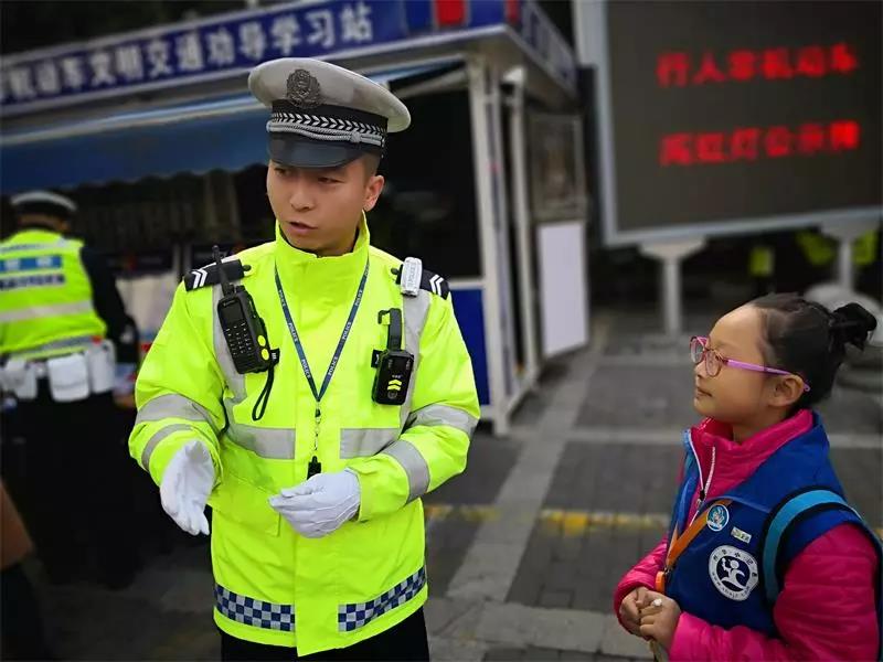 图为:新华小记者现场采访交警